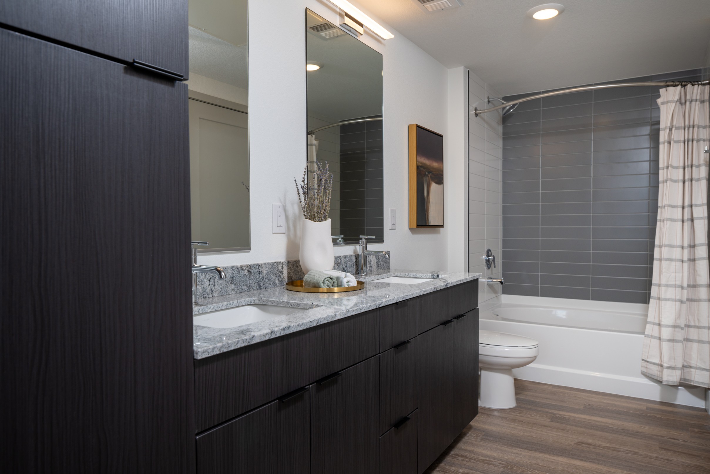 Model bathroom with double vanity and tiled shower_tub combination at Legacy Metro 525