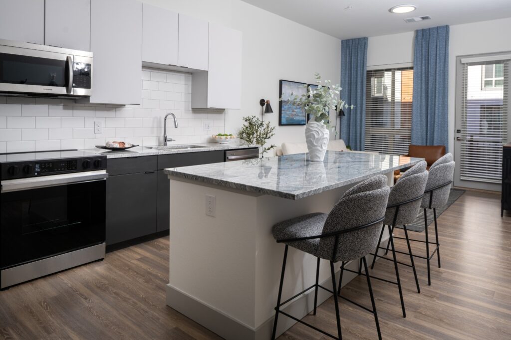 Model kitchen with large island and stainless-steel appliances