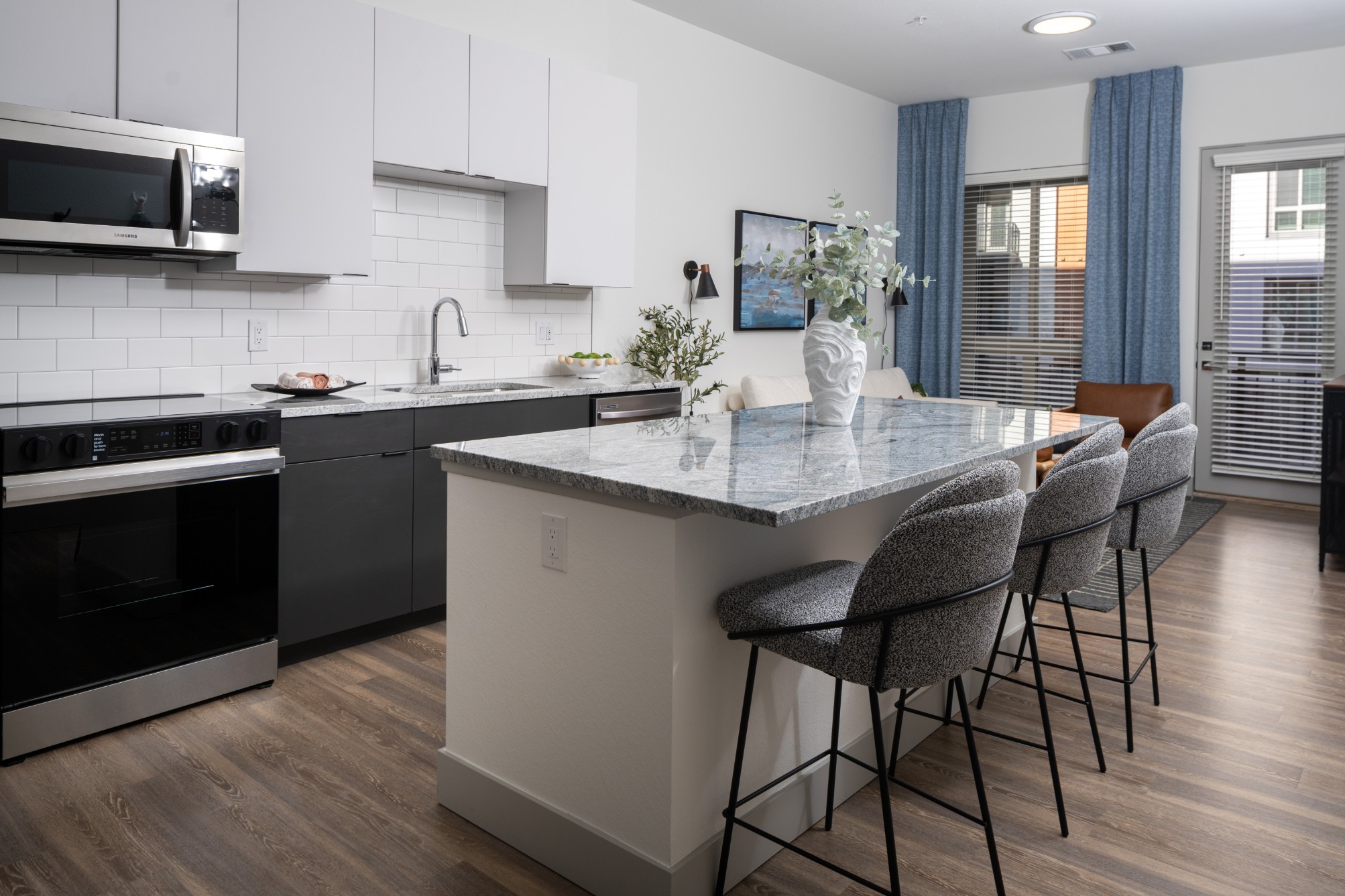 Model kitchen with large island and stainless-steel appliances