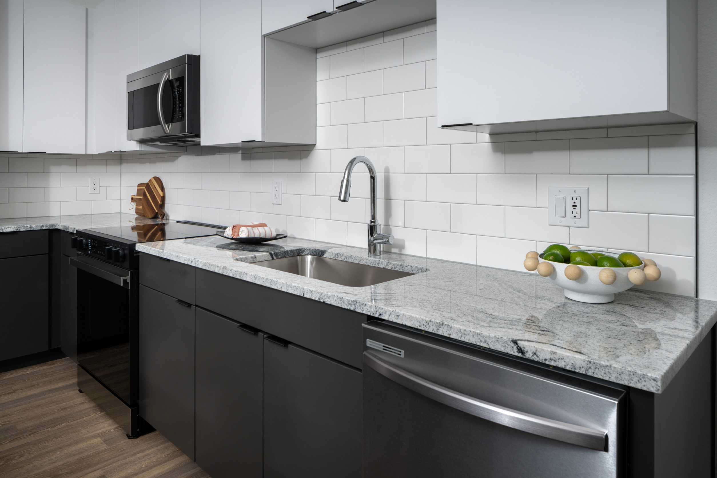 Model kitchen with tile backsplash and gooseneck sink at Legacy Metro 525
