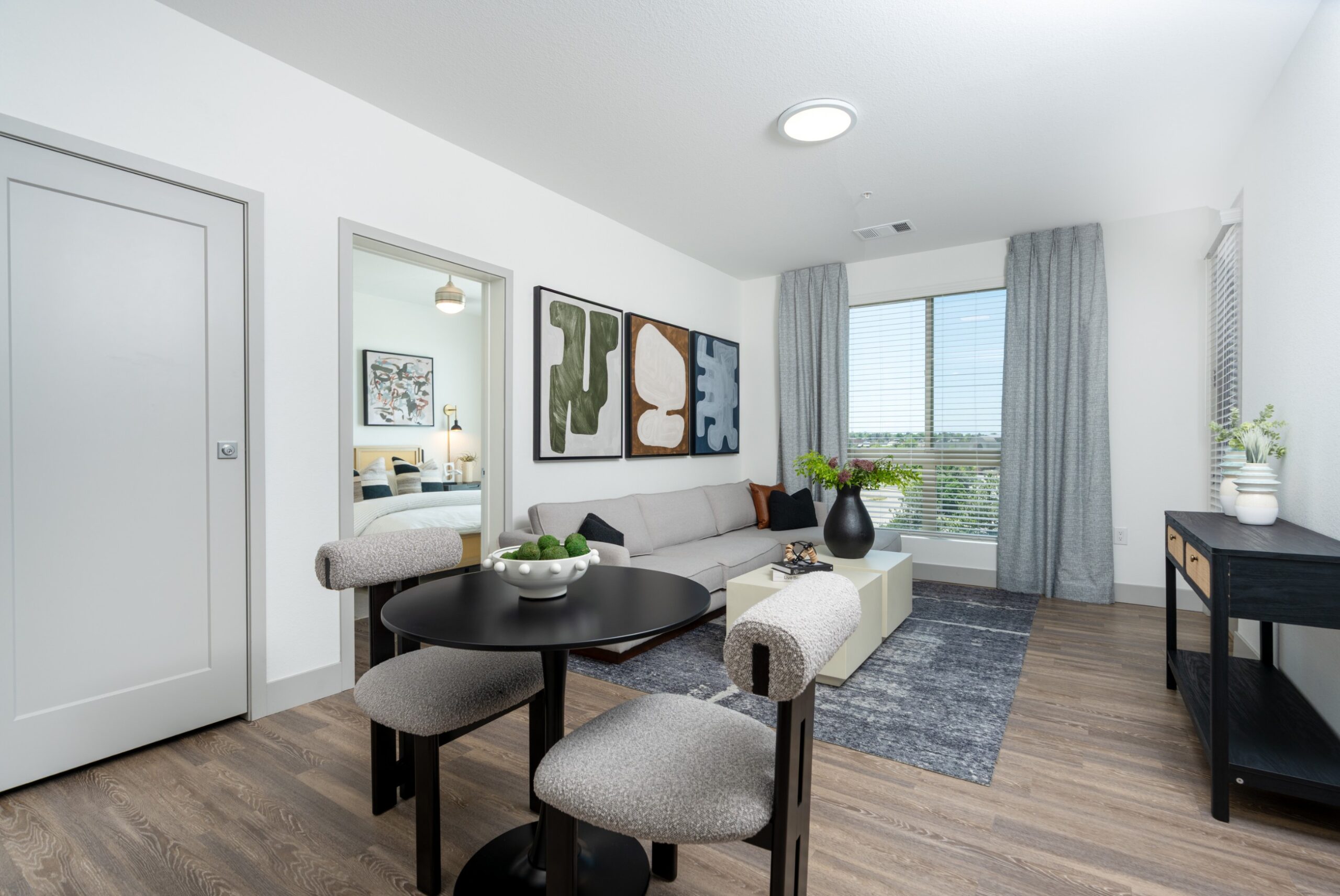 Model living room and dining in a spacious sunlit apartment