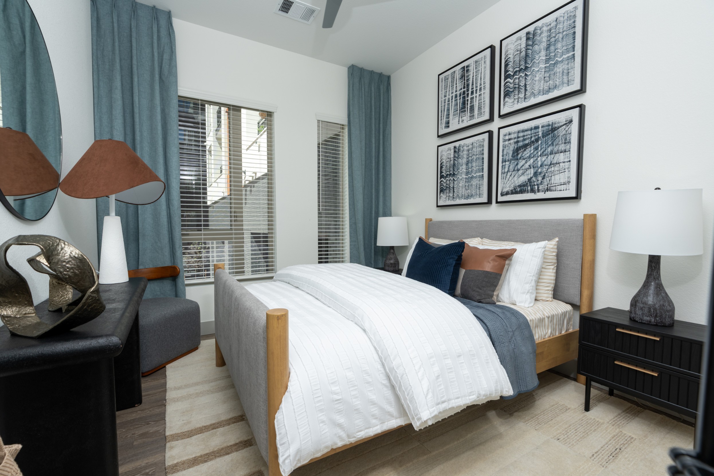 Model bedroom with high ceilings and hardwood-style flooring
