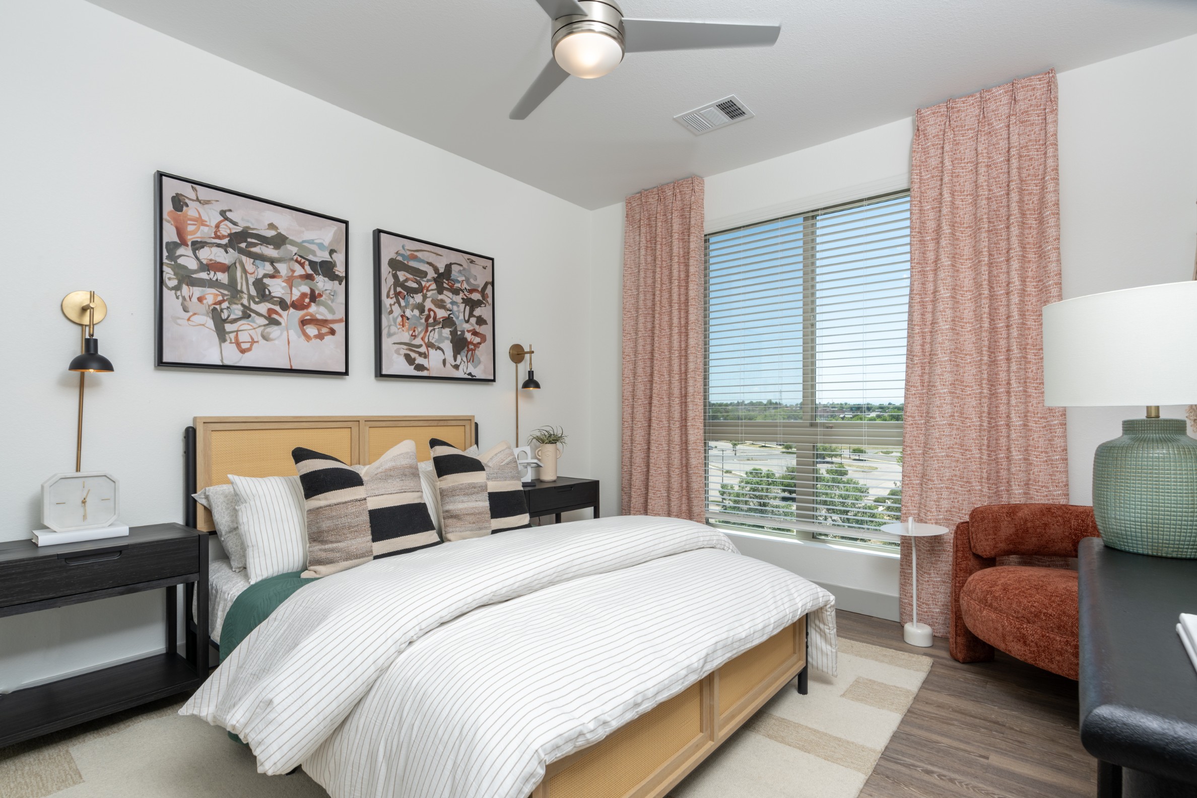 Stylish model bedroom with a ceiling fan and large window