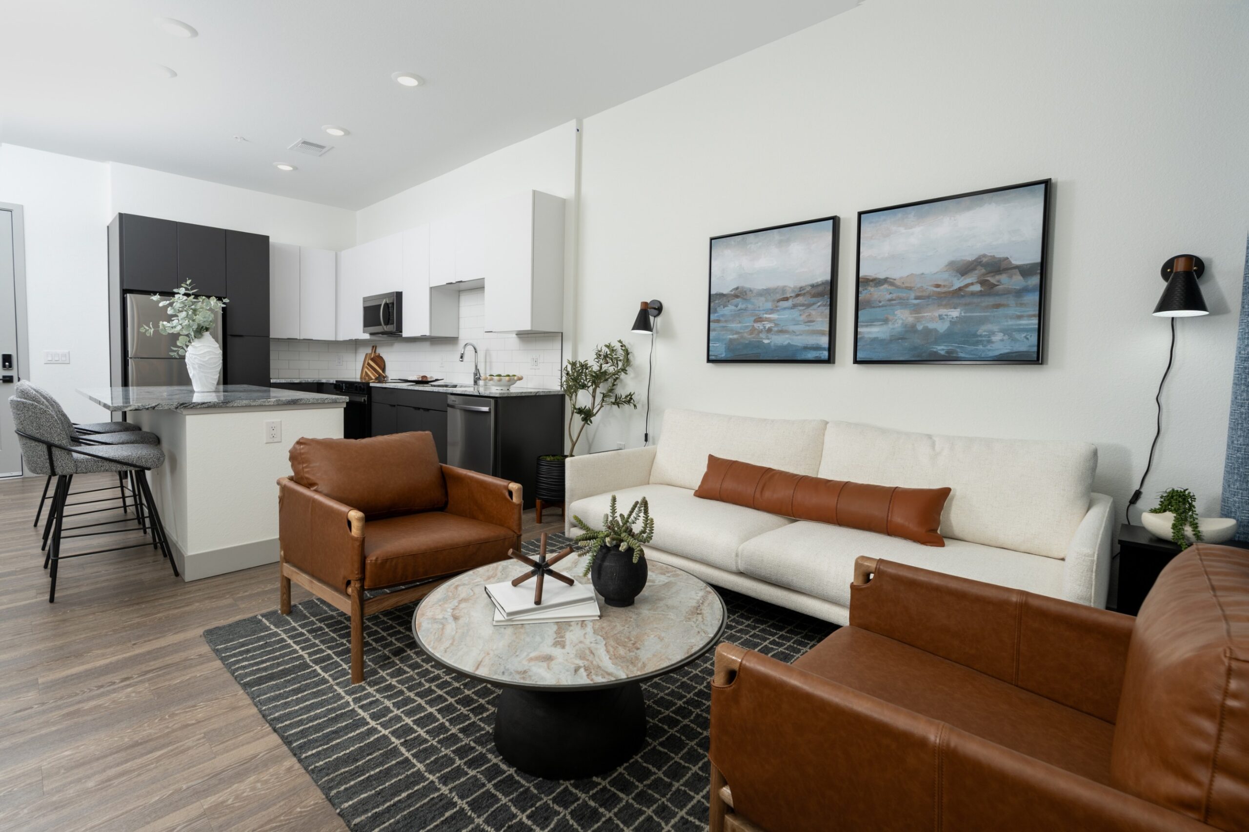 Model living room and open kitchen with hardwood-style plank flooring